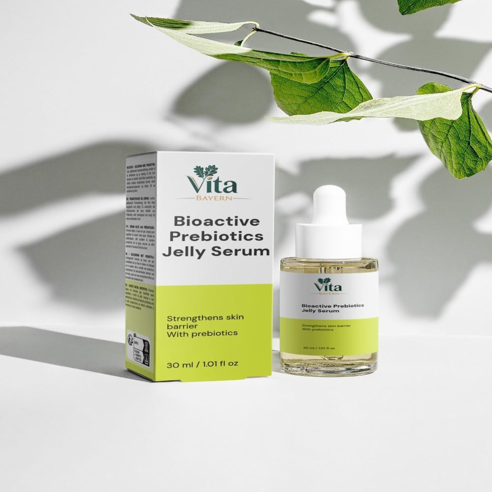 Eine 30-ml-Flasche und eine Verpackung des Vita Elixia Bioactive Prebiotics Jelly Serum zur Stärkung der Hautbarriere, ausgestellt im Schatten eines zarten botanischen Blattes