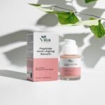 Eine Flasche und eine Schachtel Vita Elixia Peptide Anti-Aging Serum im sanften Schatten der grünen Blätter