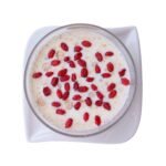 Ein Blick von oben auf eine weiße Schale mit cremigem Joghurt, gekrönt von einer großzügigen Portion leuchtend roter, getrockneter Bio-Berberitzen.